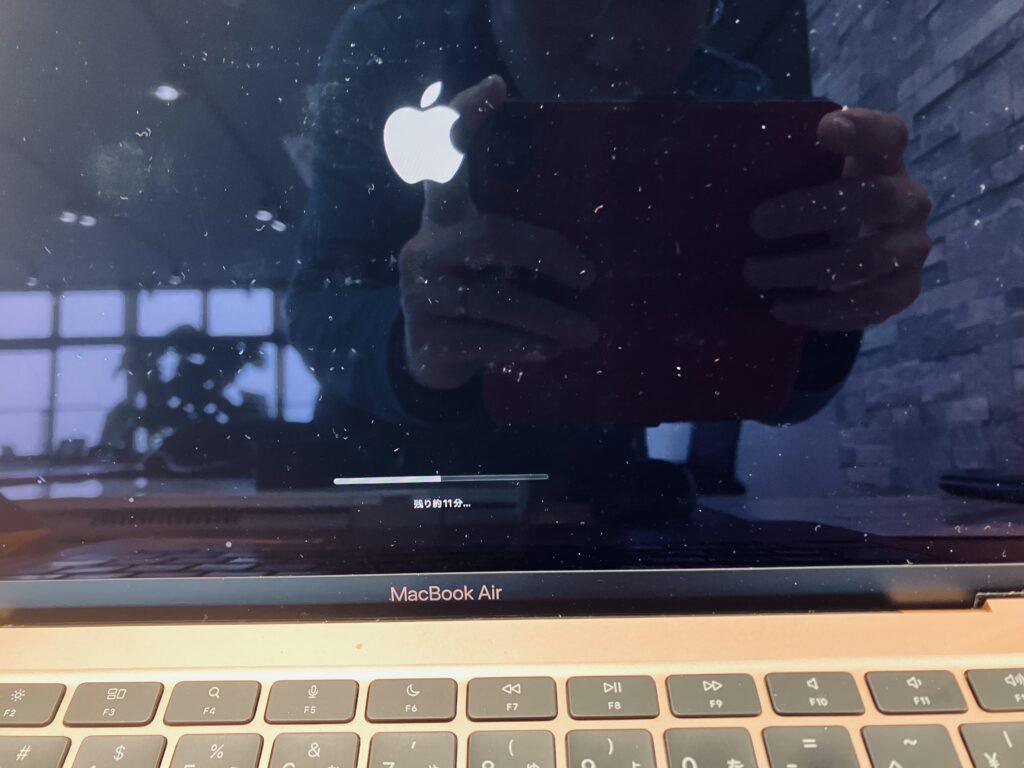 MacBookAirのOSインストール進行画面。黒画面にアップルのロゴが浮かんでいる